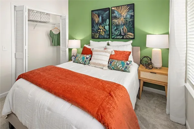 a bedroom with a bed and dresser next to a window