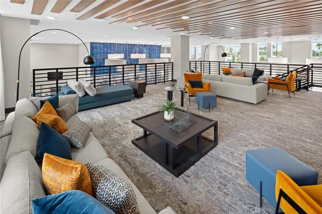 a living room with furniture wooden floor and wall paintings