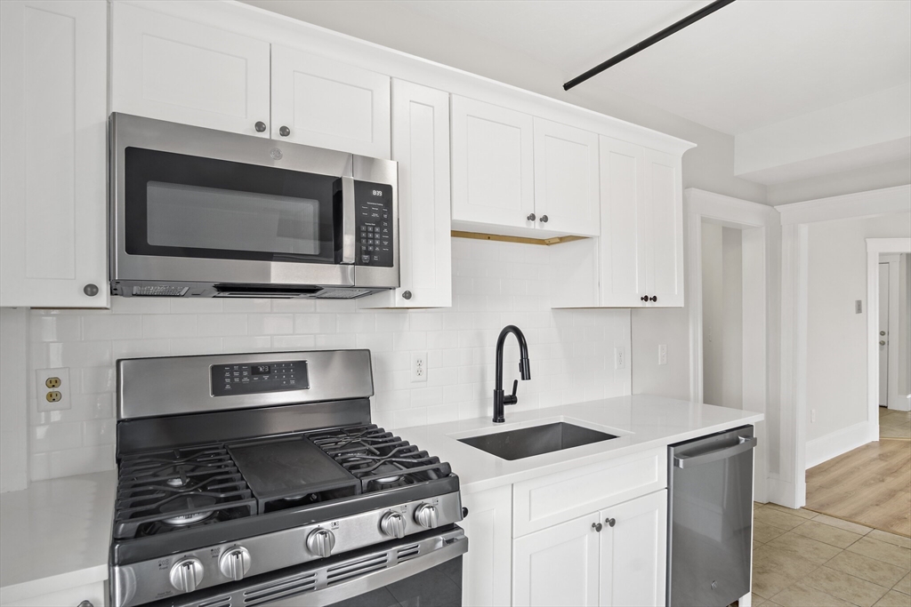 400-412 Neponset Avenue Boston, MA 02122 - Photo 19 of 31 a kitchen with stainless steel appliances a stove a microwave and sink