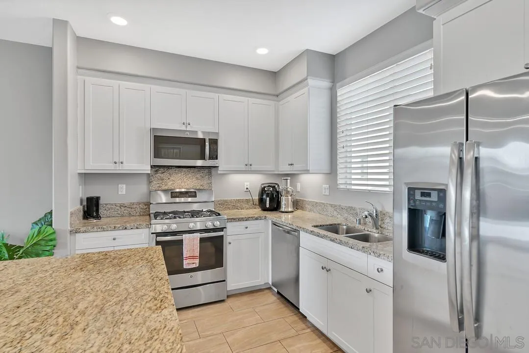 2840 Athens Road, Unit 10 Chula Vista, CA 91915 - Photo 5 of 35 a kitchen with white cabinets and stainless steel appliances