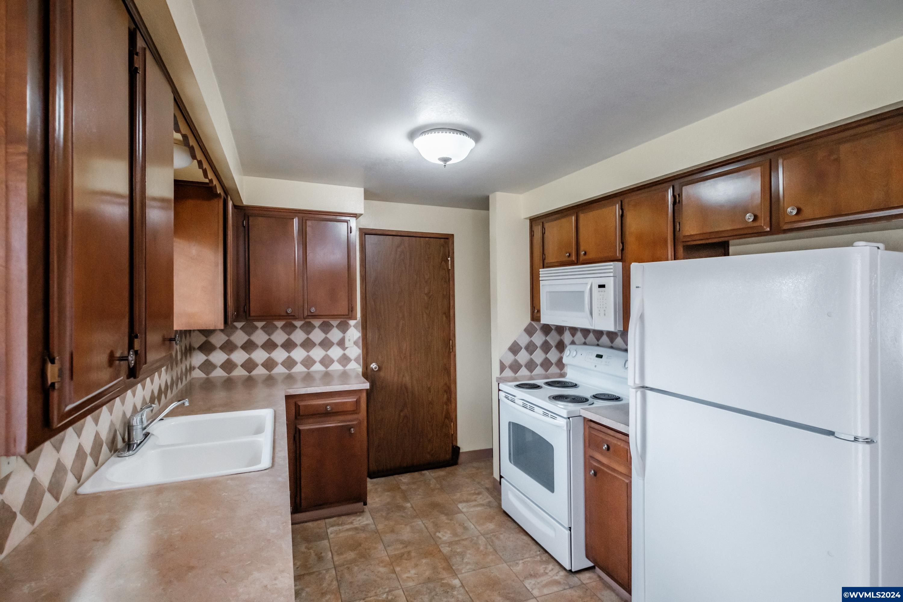 4775 Swegle Road Northeast Salem, OR 97305 - Photo 9 of 38 a kitchen with stainless steel appliances a refrigerator and a stove top oven