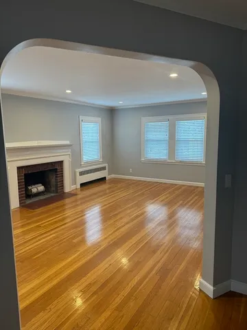 a view of empty room with wooden floor and fireplace