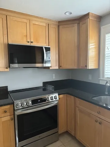 a kitchen with wooden cabinets and a stove top oven
