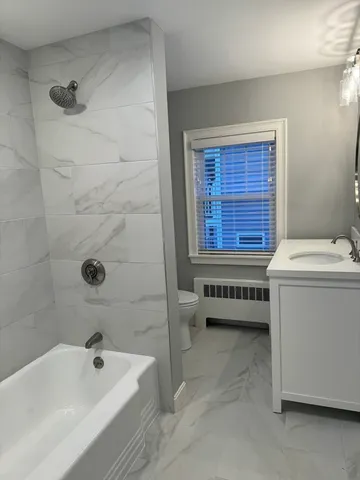 a bathroom with a tub sink and toilet