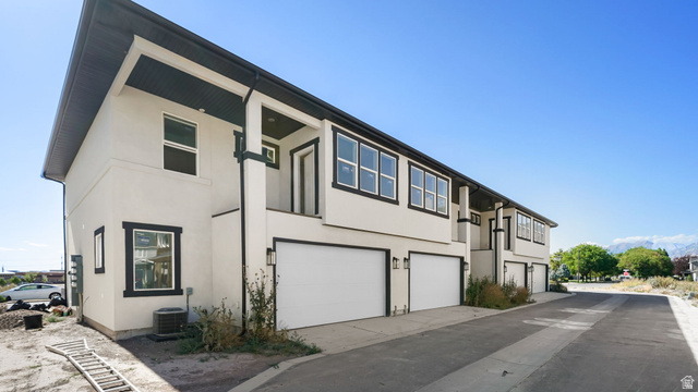 729 South Harrison Drive West Springville, UT 84663 - Photo 23 of 36 Modern townhouse exterior featuring a neutral stucco finish and contrasting dark trim