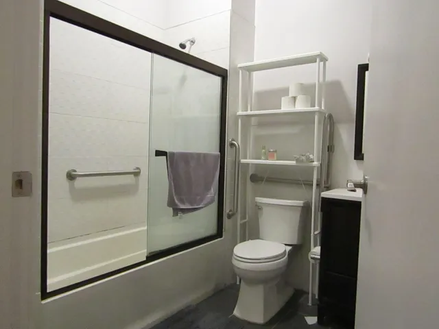 a bathroom with a toilet and a glass shower door
