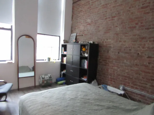 a bedroom with a bed and a potted plant