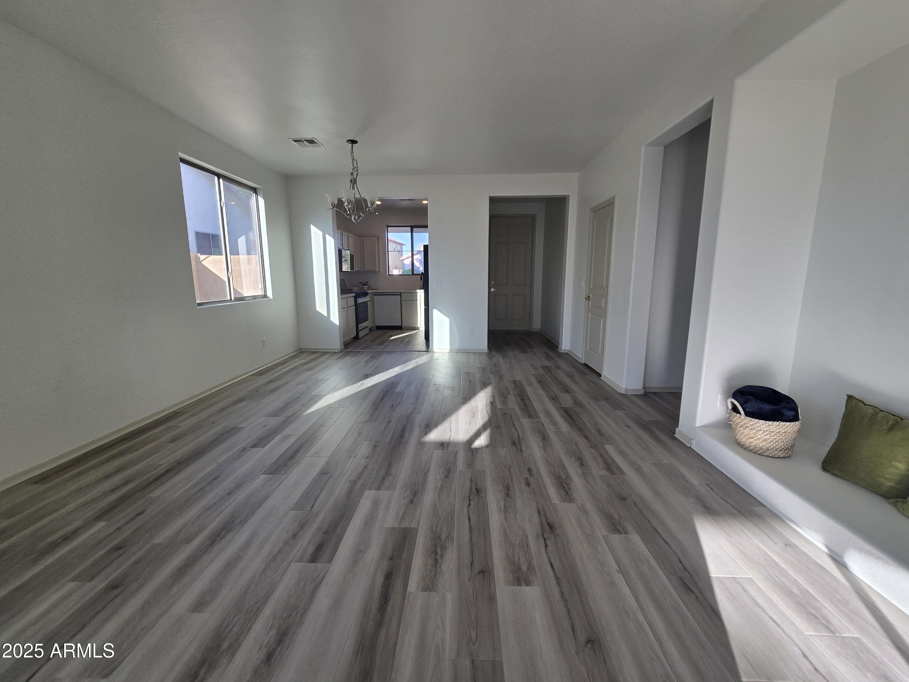 18196 Calacera Street Maricopa, AZ 85138 - Photo 4 of 21 a view of a room with wooden floor ceiling fan and window