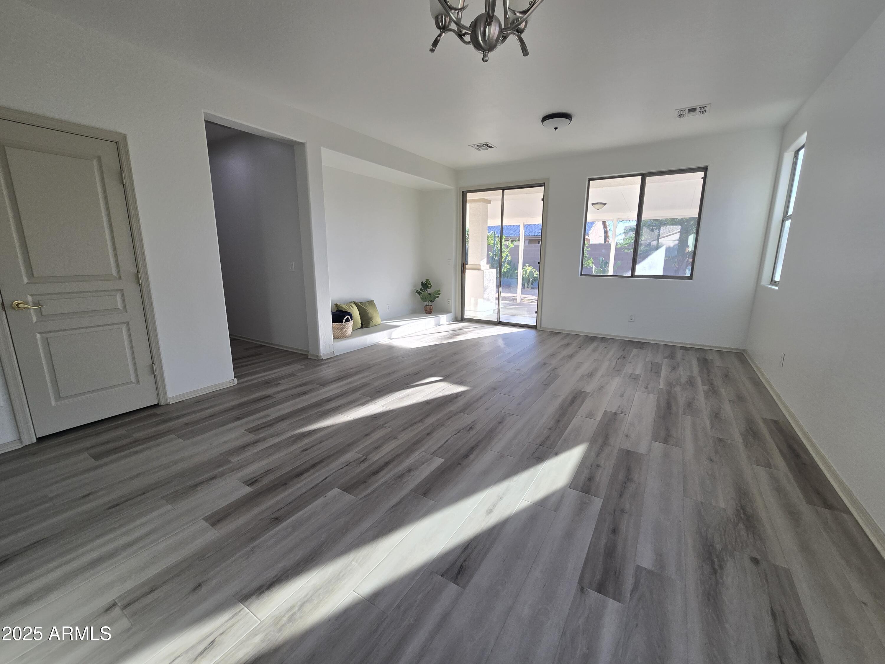 18196 Calacera Street Maricopa, AZ 85138 - Photo 5 of 21 wooden floor in an empty room with a window