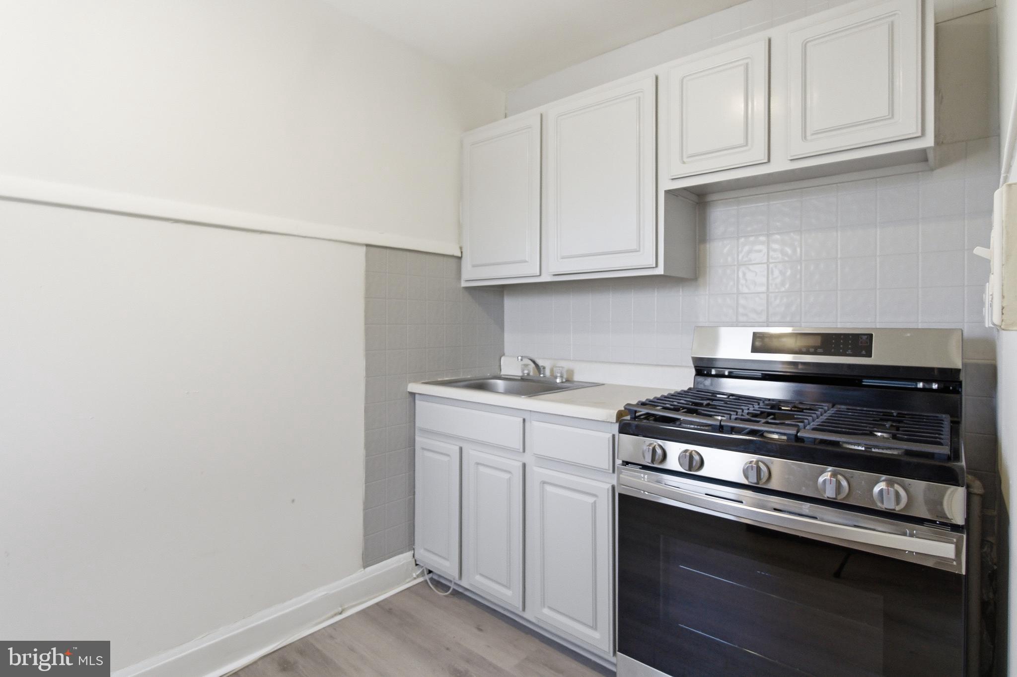 1509 Filbert Street Curtis Bay, MD 21226 - Photo 5 of 30 a kitchen with stainless steel appliances a stove and white cabinets