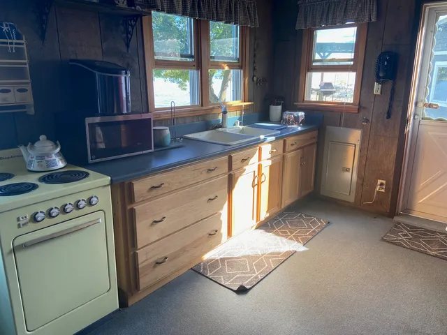 a kitchen with a stove a sink and a window