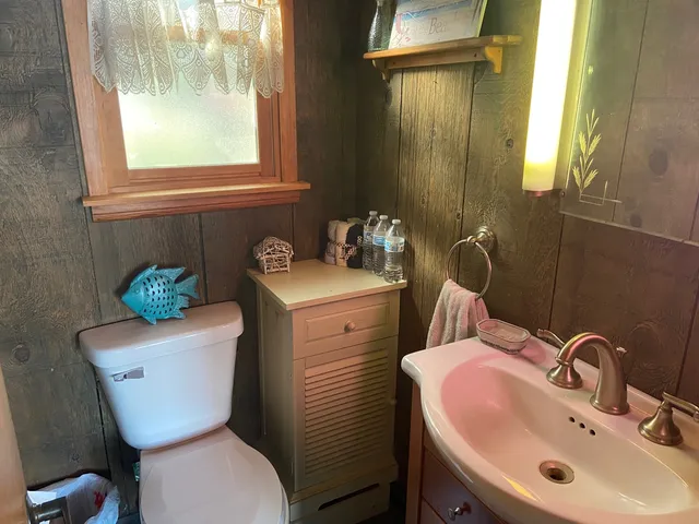 a bathroom with a toilet sink and mirror