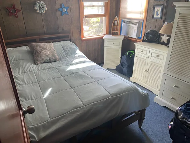 a bedroom with a bed and a window