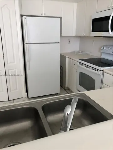 a kitchen with a refrigerator and a stove