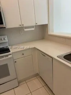 a kitchen with white cabinets and white appliances
