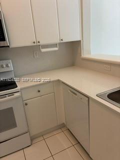 1692 Southeast 29th Court, Unit 206 Homestead, FL 33035 - Photo 5 of 15 a kitchen with white cabinets and white appliances