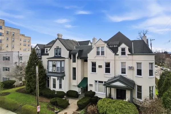 a view of a white house with a yard and potted plants
