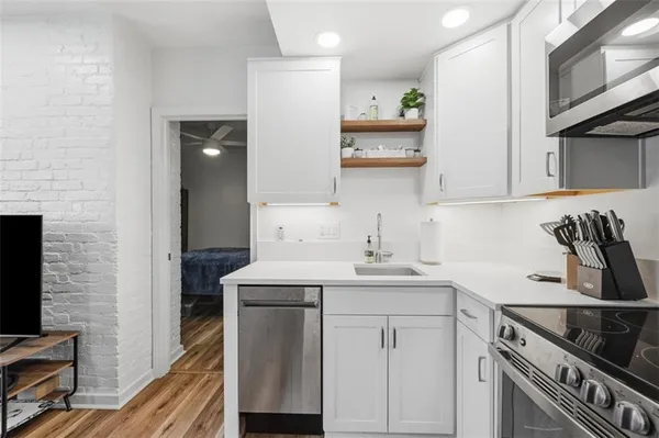 a kitchen with stainless steel appliances a sink stove and cabinets