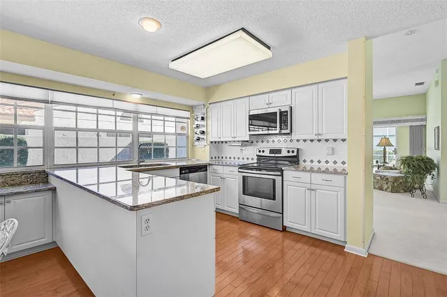 a kitchen with stainless steel appliances granite countertop a stove a sink and a refrigerator