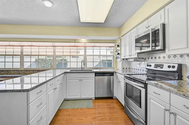 a kitchen with stainless steel appliances granite countertop a stove and a sink