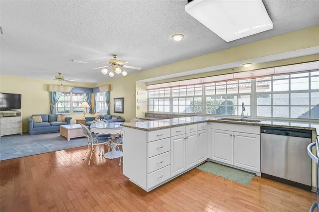 a large kitchen with stainless steel appliances granite countertop a stove and a large window