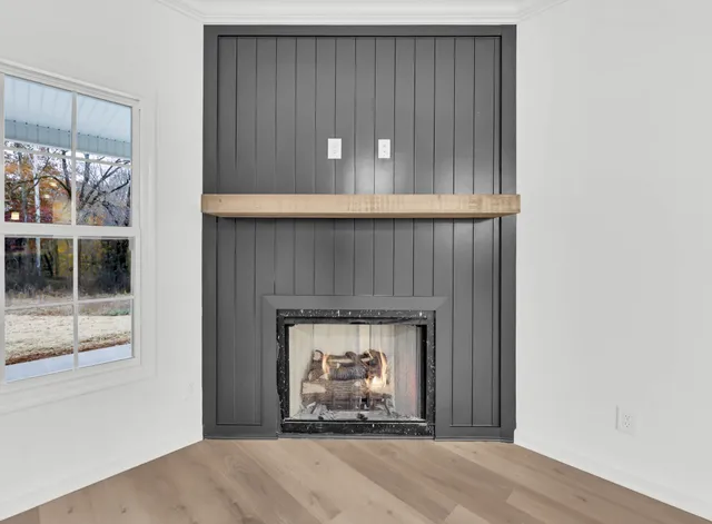 a view of an empty room with a fireplace and a window