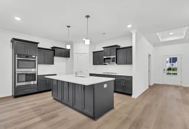 a kitchen with stainless steel appliances kitchen island a cabinets and wooden floor