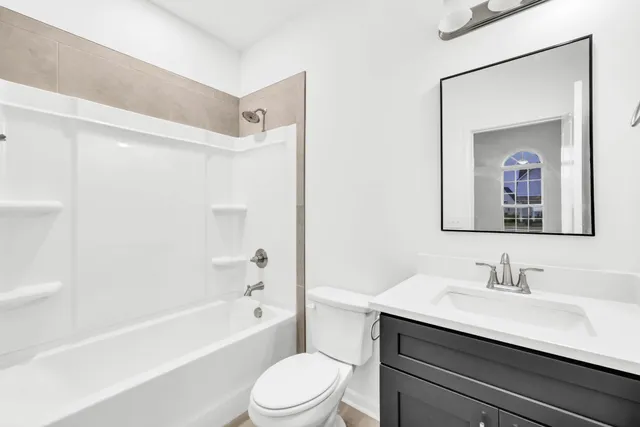 a bathroom with a sink a toilet a mirror a shower a vanity and bathtub