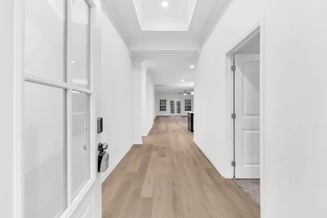 a view of a hallway with wooden floor and staircase