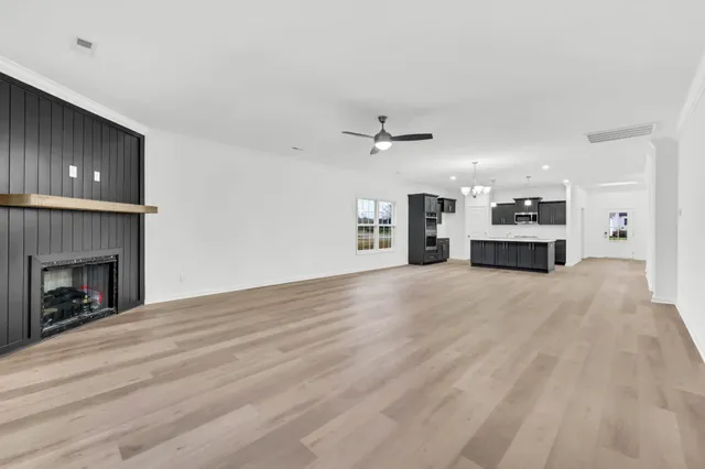 a view of a livingroom with a fireplace a chandelier and wooden floor