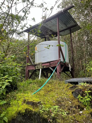 a view of a wooden house with a small yard and sitting area