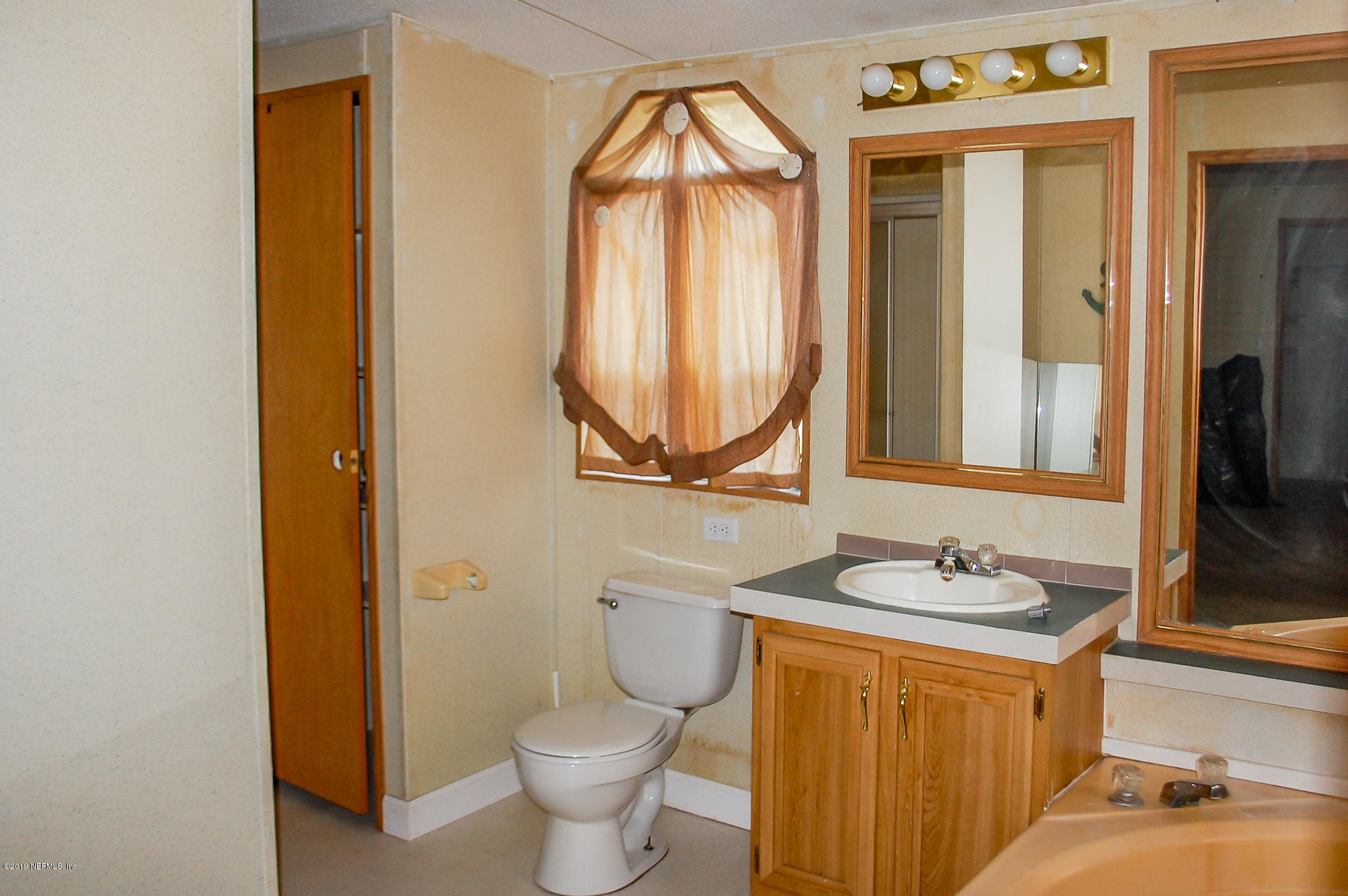 622 Lake Susan Road Hawthorne, FL 32640 - Photo 21 of 50 a bathroom with a granite countertop toilet sink and mirror
