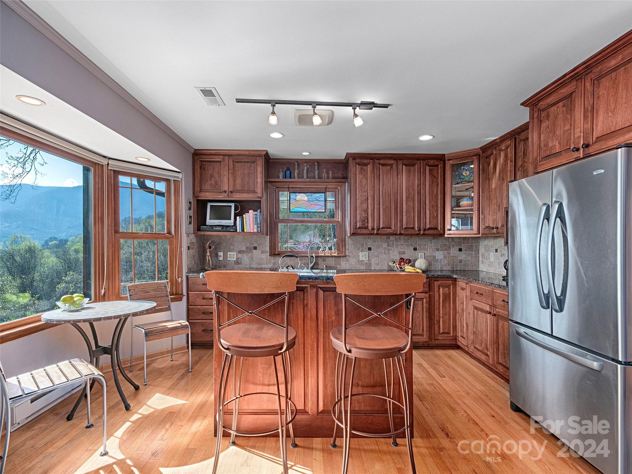 436 Old Fiddle Road Waynesville, NC 28786 - Photo 7 of 18 a kitchen with stainless steel appliances granite countertop a refrigerator a sink dishwasher a dining table and chairs with wooden floor