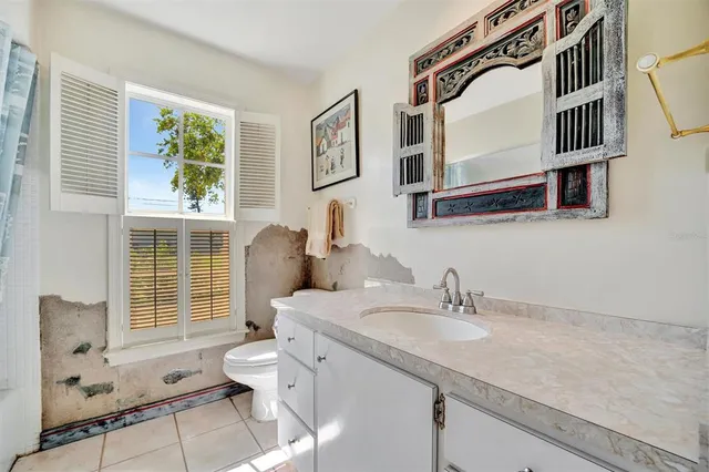a bathroom with a granite countertop sink mirror and toilet