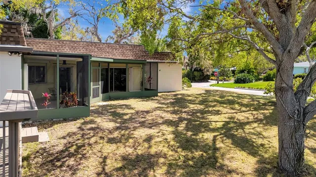 a view of a house with a tree in front of it