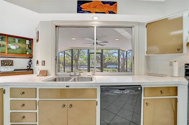 a kitchen with a sink and a large mirror next to a window