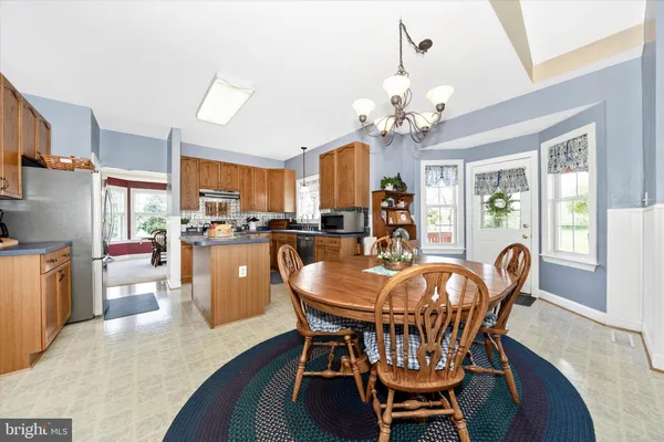a dining room with furniture a chandelier and window