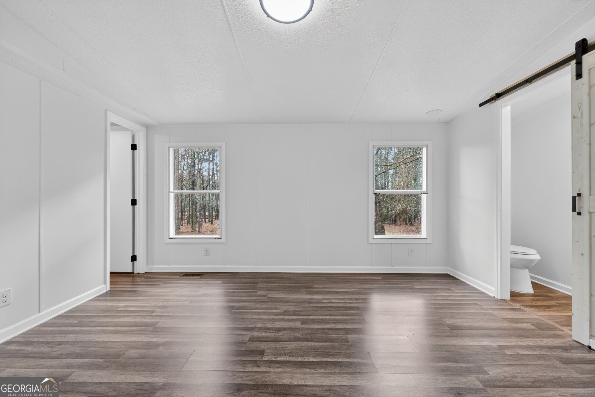 459 Hay Road Meansville, GA 30256 - Photo 19 of 36 an empty room with wooden floor and windows