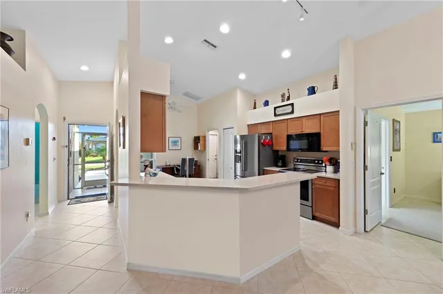 a kitchen with stainless steel appliances granite countertop a refrigerator and a stove top oven