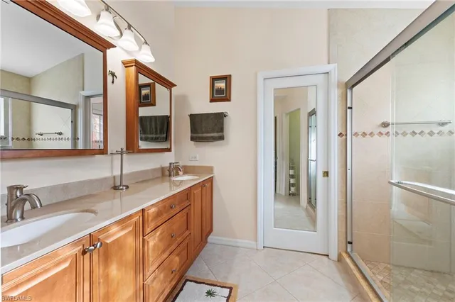 a bathroom with a double vanity sink a mirror and shower