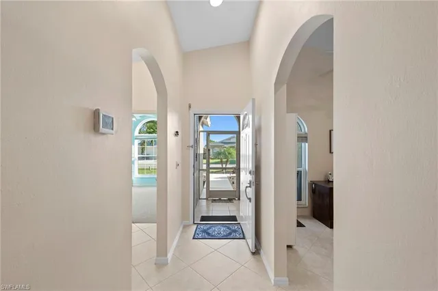 a view of a hallway with wooden floor and a living room