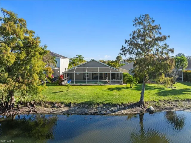 a view of a big house with a big yard and large trees