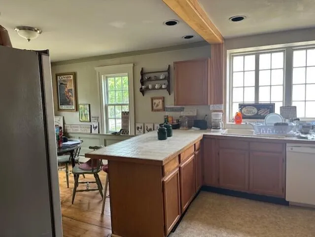 a kitchen with a stove a sink a refrigerator and chairs