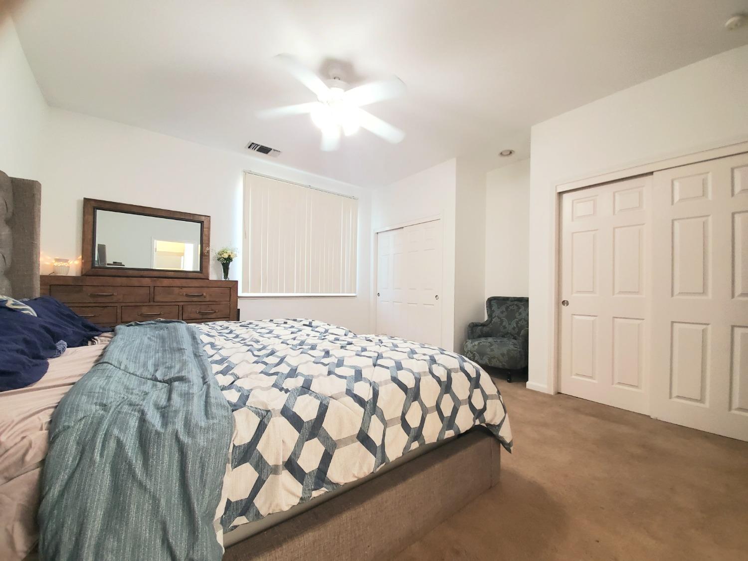 359 Amber Dinuba, CA 93618 - Photo 11 of 22 a bedroom with a large bed and a chandelier