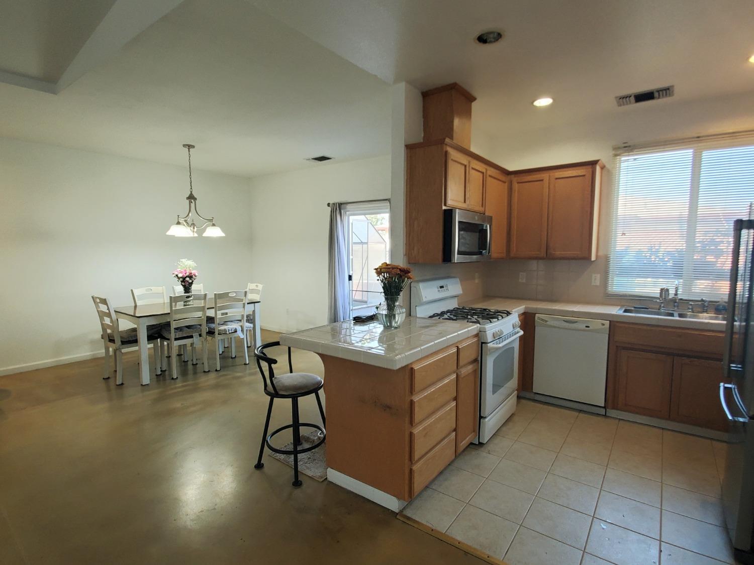 359 Amber Dinuba, CA 93618 - Photo 4 of 22 a kitchen with a stove a sink and a refrigerator