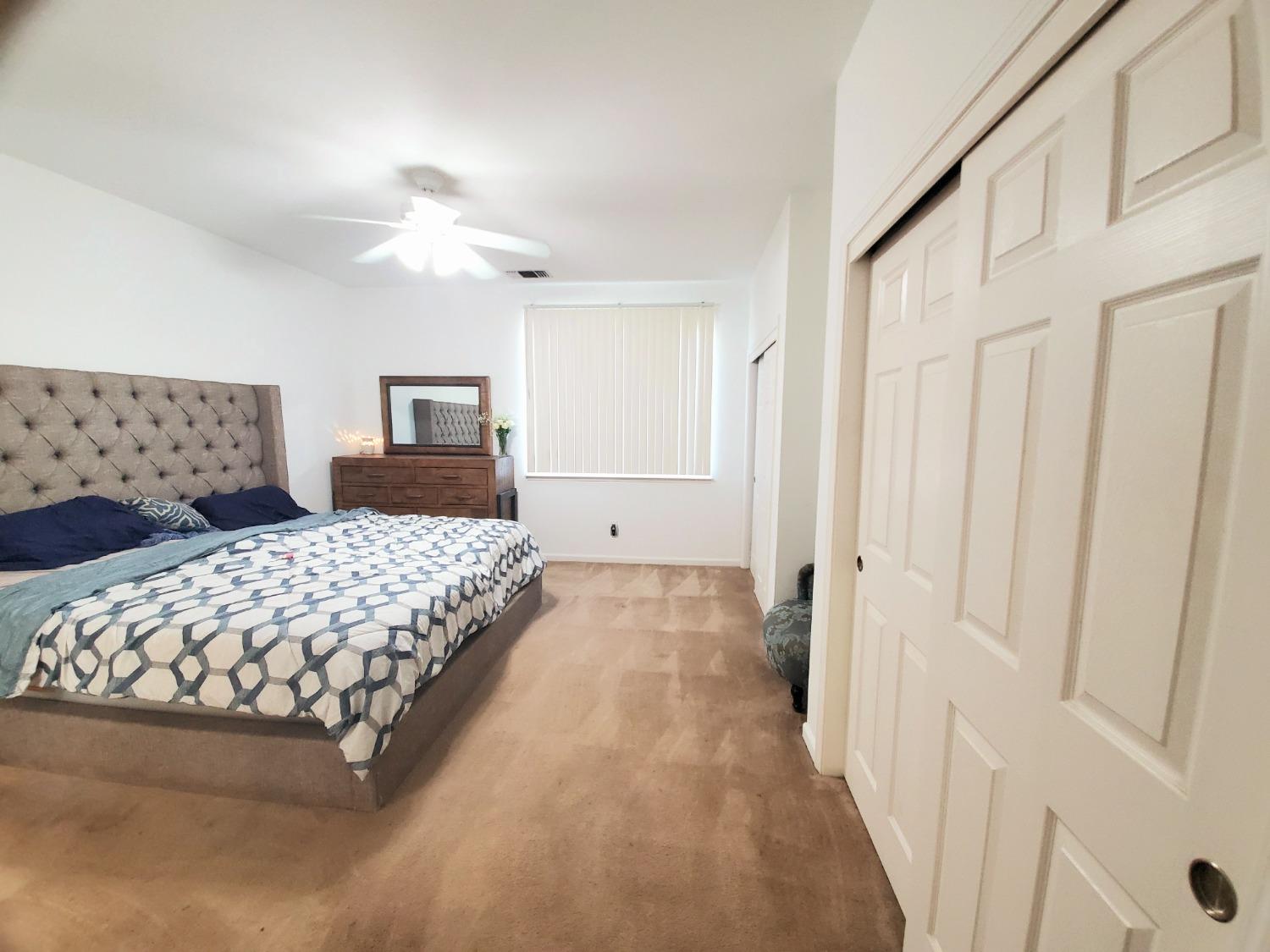 359 Amber Dinuba, CA 93618 - Photo 10 of 22 a bedroom with a large bed and a chandelier