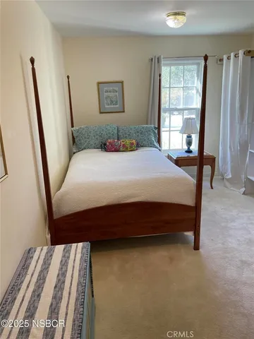 a bedroom with a bed a dresser and a window