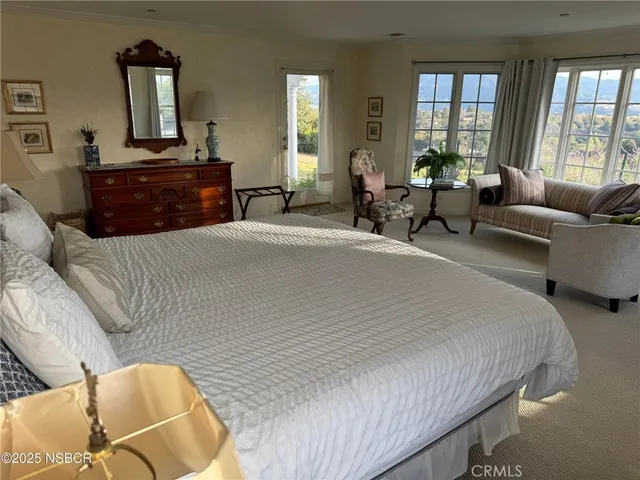 a bedroom with a bed and glass windows