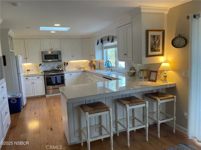 a kitchen with a table chairs refrigerator and microwave