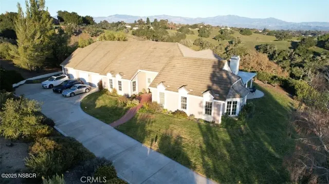 an aerial view of residential houses with outdoor space and trees